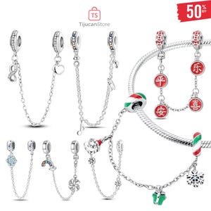 Puede incluir: Una colección de pulseras de abalorios y abalorios de plata. Los abalorios incluyen un símbolo de infinito, un corazón, notas musicales, un copo de nieve, un regalo y caracteres chinos. Los abalorios están conectados por una cadena.