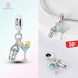May include: Silver charm with a cocktail shaker and a martini glass. The shaker has colorful gems and star cutouts. The martini glass has a blue liquid, a lemon slice, and a yellow star. The charm is designed for a bracelet.