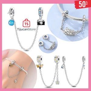 May include: A collection of silver charm bracelets and charms. Charms include a camera, a bee, a globe with an airplane, a cat in a boat, a flower, and a key. The charms are connected to the bracelet with a chain.