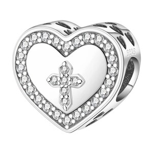 May include: A silver heart-shaped charm with a cross design. The charm features a heart outline with a border of small, clear gemstones. Inside the heart is a cross, also adorned with gemstones. The charm is likely made of sterling silver.