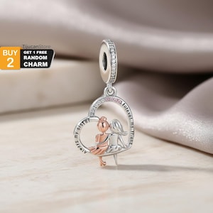 Op de afbeelding: Een zilveren bedel met een hartvormige hanger met twee figuren, één in roségoud en de andere in zilver, die samen zitten. Het hart is gegraveerd met "Always my sister" en "forever my friend". De bedel heeft een sprankelende bovenkant.