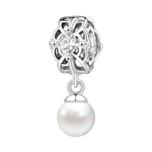 May include: A silver charm with a square, clear gemstone at the center of an openwork design. A white pearl dangles below. The charm is likely for a bracelet or necklace, and is a jewelry item.