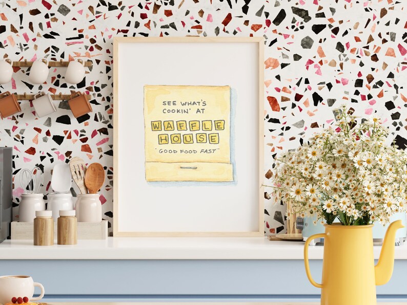 K&ouml;nnte beinhalten: Eine Aquarellillustration eines gelben Streichholzschachtels mit dem Text "See what's cookin' at Waffle House - Good Food Fast" darauf.