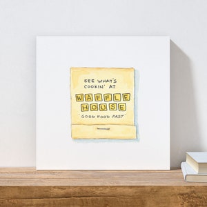 K&ouml;nnte beinhalten: Eine Aquarellillustration eines Streichholzschachtels mit dem Text "See what's cookin' at Waffle House - Good food fast" auf gelbem Hintergrund.