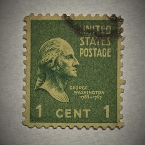 Puede incluir: Un sello postal estadounidense vintage verde de 1 centavo con un retrato de George Washington con el texto "UNITED STATES POSTAGE" y "GEORGE WASHINGTON 1789-1797".