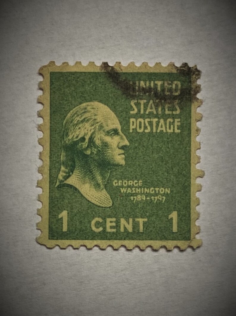 Puede incluir: Un sello postal estadounidense vintage verde de 1 centavo con un retrato de George Washington con el texto "UNITED STATES POSTAGE" y "GEORGE WASHINGTON 1789-1797".