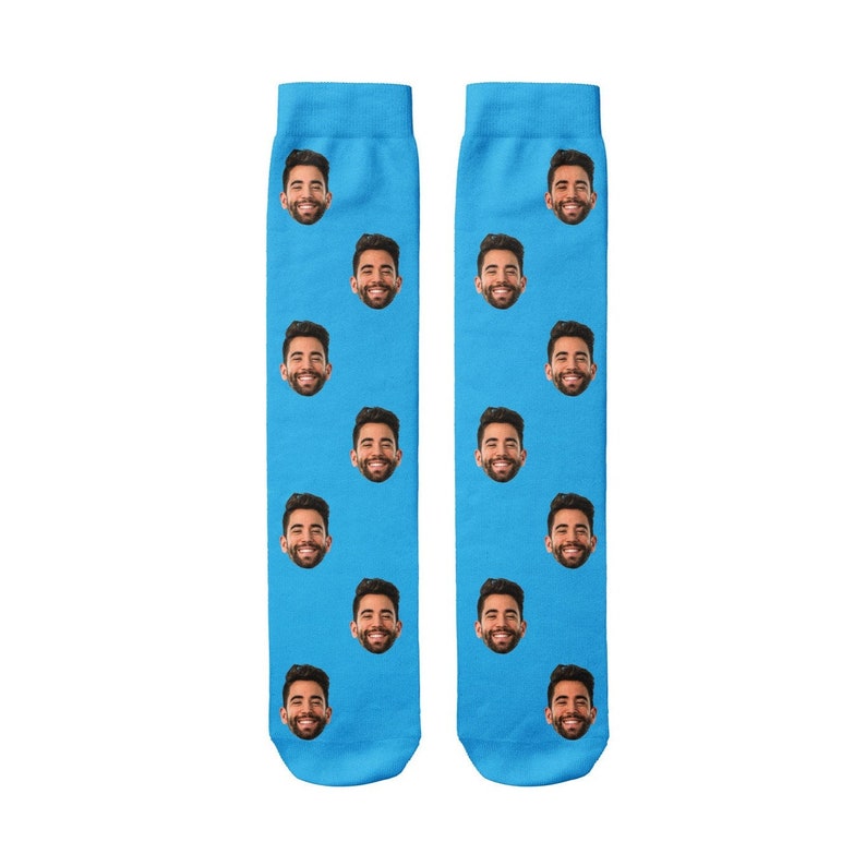 K&ouml;nnte beinhalten: Ein Paar blaue Socken mit einem sich wiederholenden Muster eines M&auml;nnergesichts.