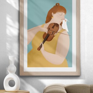 Könnte beinhalten: Illustration einer Person, die Geige spielt, ein gelbes Kleid trägt und einen weißen Vogel auf der Schulter hat. Das Kunstwerk ist in einem hellen Holzrahmen gerahmt und vor einem hellblauen Hintergrund platziert. Eine weiße Vase und ein braunes Sofa befinden sich im Vordergrund.