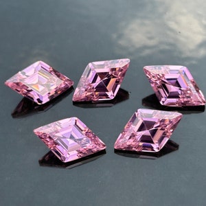 May include: Five pink, faceted, square-shaped gemstones with a diamond-like cut.
