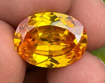 May include: A large, oval-shaped, faceted gemstone with a bright yellow and orange color.