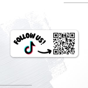 May include: A rectangular white sticker featuring the black text FOLLOW US! above a black, blue, and pink TikTok logo. A black arrow points from the logo to a black and white QR code on the right side of the sticker, which has rounded corners.