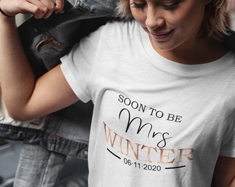 May include: White t-shirt with the text "Soon to be Mrs. Winter 06-11-2020" printed on it.