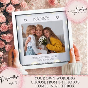 Puede incluir: Una foto enmarcada en blanco con la palabra "NANNY" encima de una foto familiar. La foto incluye el texto "WE LOVE YOU SO MUCH, JADE & ERIN XXX". El marco está sostenido por manos y rodeado de rosas rosas.