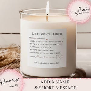 May include: A burning white candle in a clear glass jar. The candle has a label that reads "DIFFERENCE MAKER" with a definition. The text "Add a name & short message" is at the bottom. The candle is on a white surface.