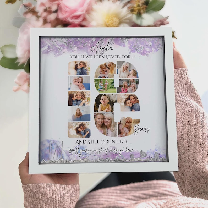 May include: A square white shadow box frame containing a personalized photo collage arranged in the shape of the number 18. The design features purple watercolor accents, the text Amelia, YOU HAVE BEEN LOVED FOR, Years, AND STILL COUNTING.