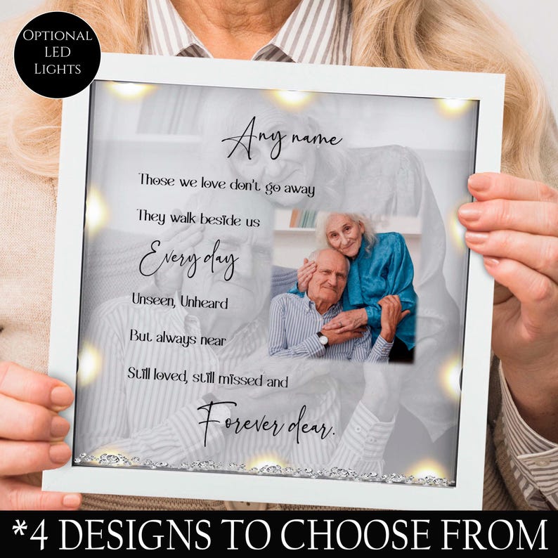 May include: White picture frame with a black and white photo of an older couple. The frame has a white background with the text "Those we love don't go away. They walk beside us Every day Unseen, Unheard But always near Still loved, still missed and Forever dear." The frame has optional LED lights.