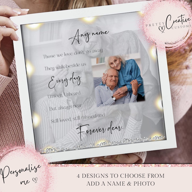 May include: A white framed photograph with a light grey background and a photo of an older couple. The text reads "Those we love don't go away, They walk beside us Every day, Unseen, Unheard, But always near, Still loved, still missed and Forever dear." The frame has a silver glitter border and small lights around the photo.