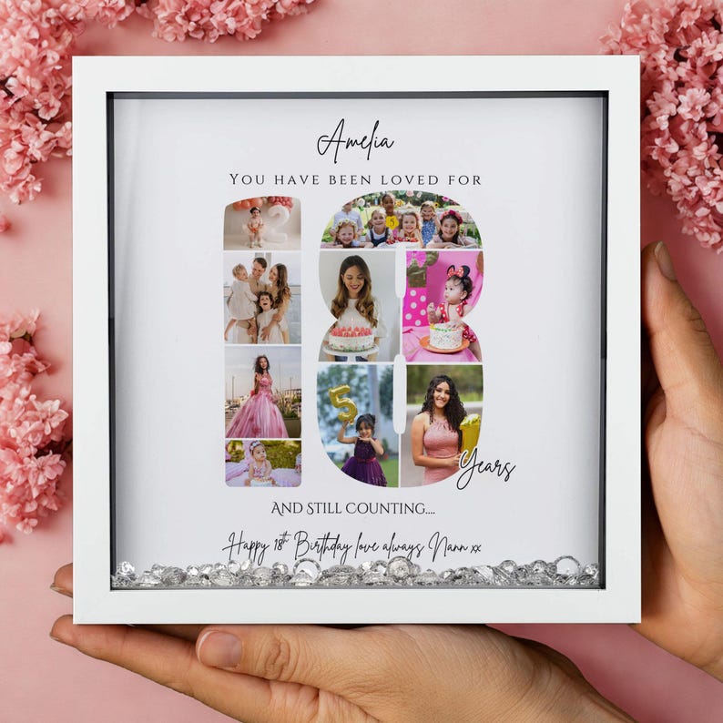 May include: A square white shadow box frame containing a photo collage arranged in the shape of the number 18. The text reads Amelia, You have been loved for 18 years, and still counting, Happy 18th Birthday love always Nann xx. Clear crystals fill the base.