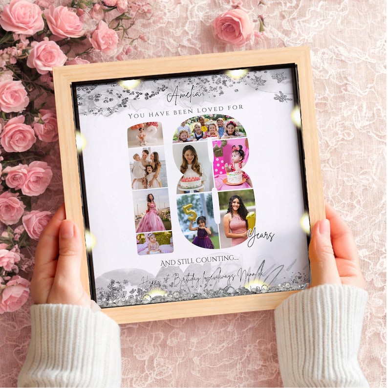May include: A square wooden frame containing a photo collage arranged in the shape of the number 18. The text reads Amelia, You have been loved for 18 years, and still counting... Happy 18th Birthday love always Nana xx. Silver glitter accents decorate the border.