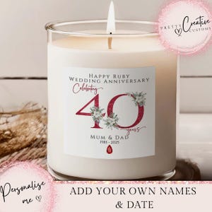 Puede incluir: Una vela encendida en un tarro de cristal transparente. La etiqueta dice "HAPPY RUBY WEDDING ANNIVERSARY Celebrating 40 years MUM & DAD 1985-2025". También se ve el texto "Personalise me" y "ADD YOUR OWN NAMES & DATE". Para un aniversario de bodas.