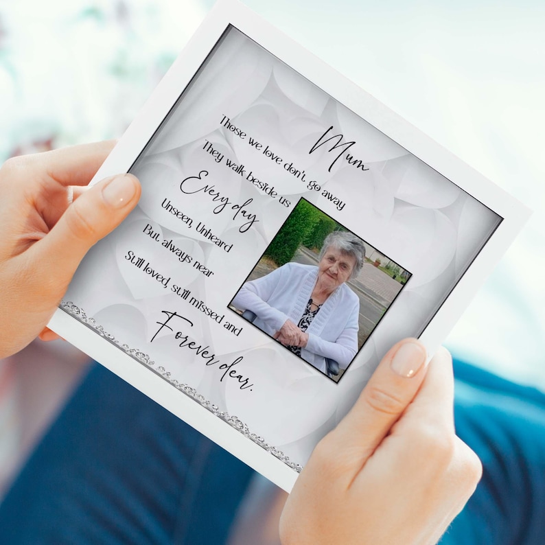 May include: A white card with a black border and silver glitter accents. The card features a photo of a woman and the text "Mum, These we love don't go away, They walk beside us, Every day, Unseen, Unheard, But always near, Still loved, still missed and Forever dear."