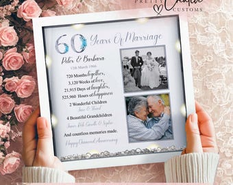 May include: A white framed print celebrating a 60th wedding anniversary. The print includes two black and white photos, names, dates, and a list of milestones. The text reads "Happy Diamond Anniversary."