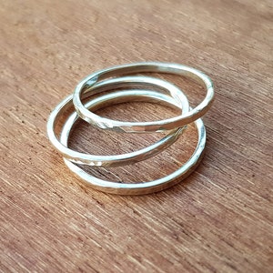May include: Three silver rings stacked on top of each other. The rings are hammered and have a textured surface.