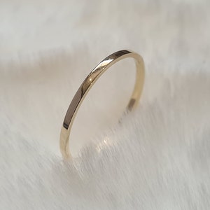 May include: A simple gold band ring, a classic and minimalist design.