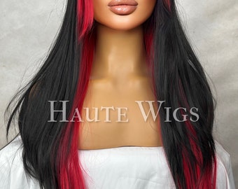 May include: A long black wig with red highlights and a side-swept fringe. The wig has the text "Haute Wigs" in the center. The wig is styled on a mannequin head against a neutral background.