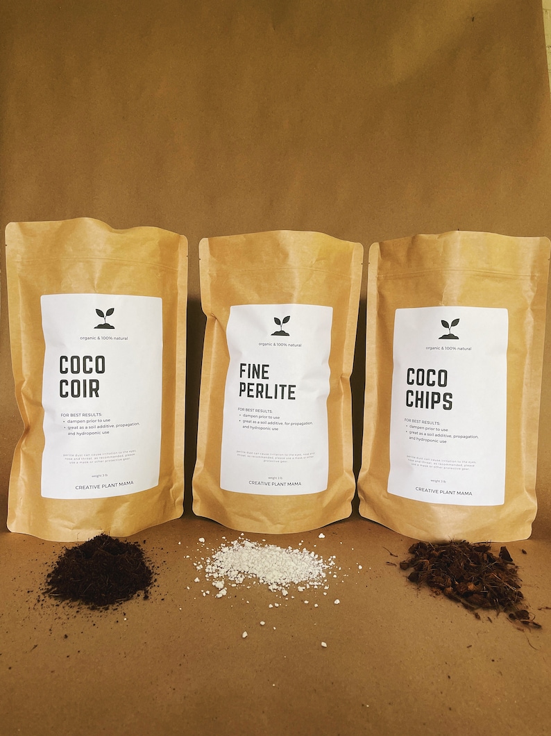 May include: Three brown paper bags labeled "COCO COIR", "FINE PERLITE", and "COCO CHIPS" with white labels and black text. Small piles of each product are in front of the bags. The text "CREATIVE PLANT MAMA" is at the bottom of each label.