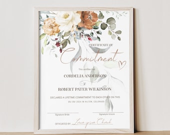 Könnte beinhalten: Ein Zertifikat der Verpflichtung mit einem floralen Design in Orange-, Weiß- und Grüntönen. Der Text lautet "Certificate of Commitment" und "This certifies that Cordelia Anderson & Robert Pater Wilkinson declared a lifetime commitment to each other on this 05/09/2024 in Hilton, Colorado." Die Unterschriftenzeile lautet "Officiated by Lorem ipsum Church."