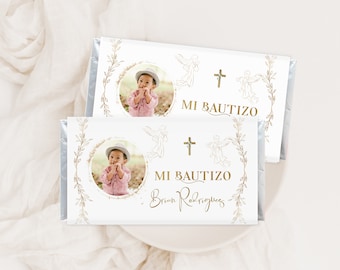 May include: Two white chocolate bar wrappers with gold foil accents. The wrappers feature a photo of a child, a cross, and angels. The text on the wrappers reads "Mi Bautizo" and "Brian Rodriguez".