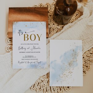 May include: A baby shower invitation with a blue watercolour background and gold glitter. The invitation reads "It's a Boy" in gold lettering and includes the names "Brittany and Alexander", the date "Saturday, 7 August 2024 at 3:00 PM", the address "1073 Sidney Erzs&eacute;bet Krt. 9-11", and the RSVP information "RSVP to Olivia at 000.000.0000". The invitation also states "Registered at Amazon and Target".