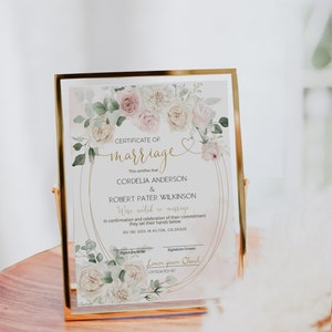 May include: A framed marriage certificate with a gold border. The certificate features the names Cordelia Anderson and Robert Pater Wilkinson, with floral accents in pink and white. The text reads "Certificate of Marriage."