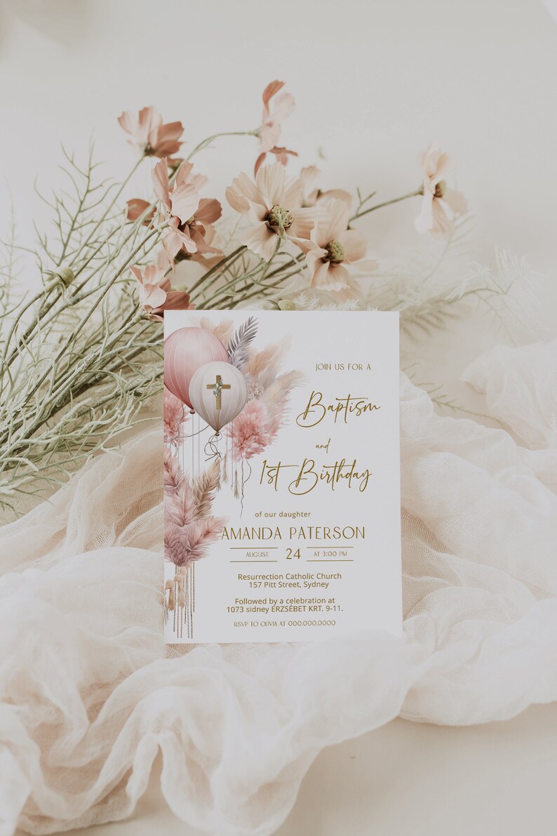 May include: A baptism and first birthday invitation with a watercolor illustration of pink and white balloons, pampas grass, and a cross. The text reads "Join us for a Baptism and 1st Birthday of our daughter Amanda Paterson August 24 at 3:00 PM Resurrection Catholic Church 157 Pitt Street, Sydney Followed by a celebration at 1073 sidney ERZS&Eacute;BET KRT. 9-11. RSVP to OUMA at 000.000.0000"