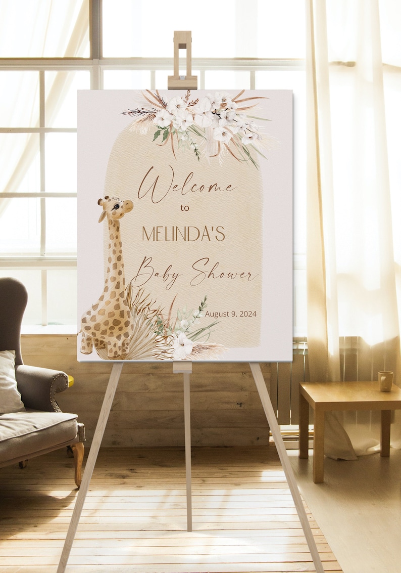 May include: Welcome to Melinda's Baby Shower sign with a giraffe illustration, white flowers, and pampas grass. The date August 9, 2024 is printed on the sign.