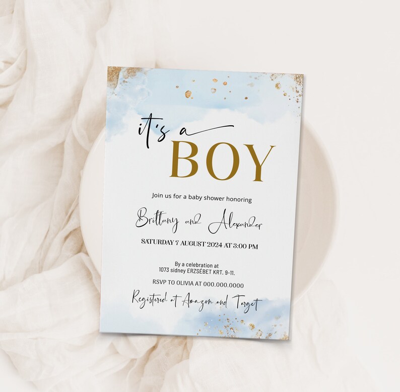 May include: A blue and gold baby shower invitation with the text "it's a BOY" in gold lettering. The invitation includes the names Brittany and Alexander, the date and time of the shower, and the location. It also includes the text "Registered at Amazon and Target".