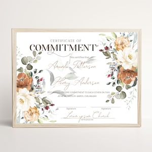 May include: A framed Certificate of Commitment featuring the text "CERTIFICATE OF COMMITMENT" with floral illustrations in shades of rust, cream, and sage green. The document includes placeholders for names, dates, location, and signatures.
