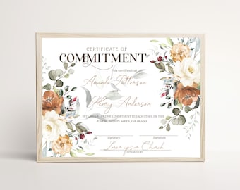 Könnte beinhalten: Ein gerahmtes Verpflichtungszertifikat mit dem Text "CERTIFICATE OF COMMITMENT" und Blumenillustrationen in Rost-, Creme- und Salbeigrüntönen. Das Dokument enthält Platzhalter für Namen, Datum, Ort und Unterschriften.