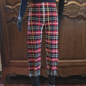 May include: Red, black, white, and yellow plaid pants with a black waistband and black trim at the bottom of the legs.