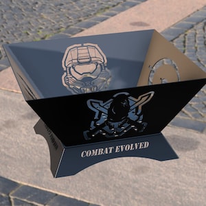 May include: Black metal fire pit with a cut-out design of a Master Chief helmet and the words "Combat Evolved".