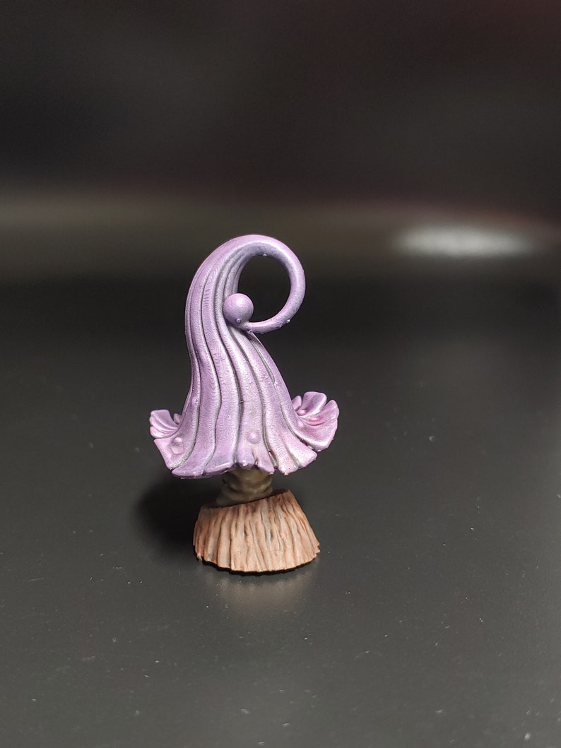 May include: A purple and brown miniature mushroom figurine with a curled top and a textured base.