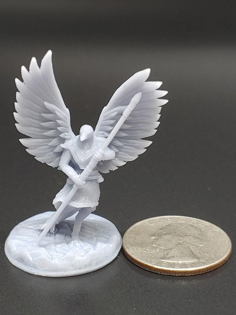 May include: A light grey miniature angel figurine with large, detailed wings, holding a staff. The angel stands on a textured base, next to a coin for size comparison. The figurine is likely 3D-printed and suitable for tabletop gaming.