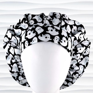 Bouffant style surgical scrub cap with white animated ghosts all over this black cotton fabric.