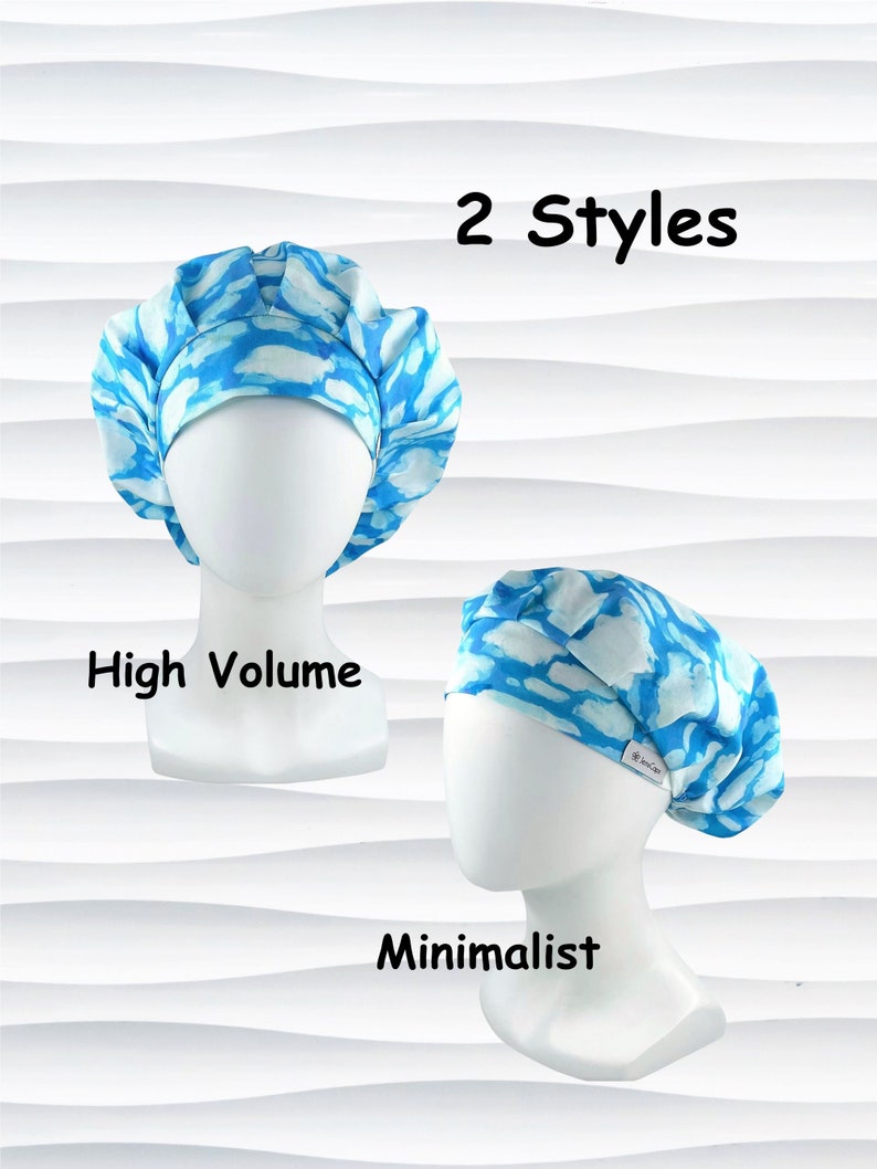 May include: Two styles of scrub caps are displayed on mannequin heads. The caps feature a blue and white cloud-like pattern. One cap is high volume, and the other is minimalist. The text "2 Styles", "High Volume", and "Minimalist" are also visible.