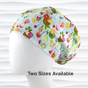 May include: A light blue surgical scrub cap with a tropical fruit and cocktail pattern. The design includes images of pineapples, watermelons, cherries, and cocktails. The text "Two Sizes Available" is displayed on the bottom of the image.