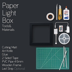May include: A flat lay image showing the materials and tools needed to make a paper light box. The materials include a wooden frame, a cutting mat, a glue stick, a roll of double-sided tape, a roll of LED strip lights, a PVC pipe, and an art knife. The tools include a remote control, a power adapter, and a roll of tape.
