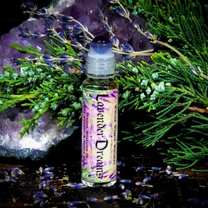 Puede incluir: Una peque&ntilde;a botella de vidrio con un aplicador de bola. La botella est&aacute; etiquetada con "Lavender Dreams" y "Winter Willow Witchery." La botella est&aacute; rodeada de flores de lavanda y un cristal morado.