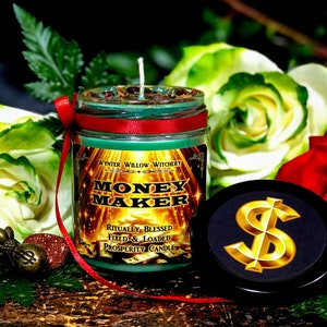 Puede incluir: Un tarro de vidrio verde con una vela, una cinta roja y una etiqueta dorada que dice "Money Maker -  Ritually Blessed Fixed & Loaded Prosperity Candle". La vela est&aacute; rodeada de rosas blancas y rojas y follaje verde. La tapa del tarro tiene un signo de d&oacute;lar dorado.