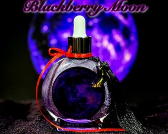 May include: A round, purple glass bottle with a dropper, red ribbon, and black tassel. The bottle has a dark purple liquid inside and the words "Blackberry Moon" and "Wynter Willow Witchery" are written on the image. A purple orb is in the background.